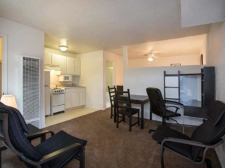 A Kitchenette on the left with a small dining table in the middle and office area on right